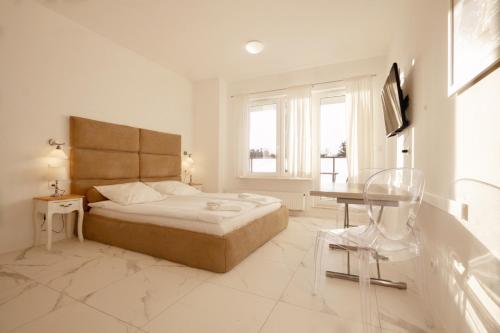 um quarto branco com uma cama e uma banheira em Onyx by Baltic Home em Międzyzdroje