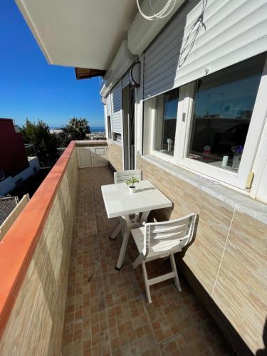een tafel en stoelen op het balkon van een huis bij camera vista mare in Anacapri
