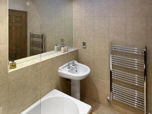 a bathroom with a sink and a toilet and a mirror at Oak in Falmouth