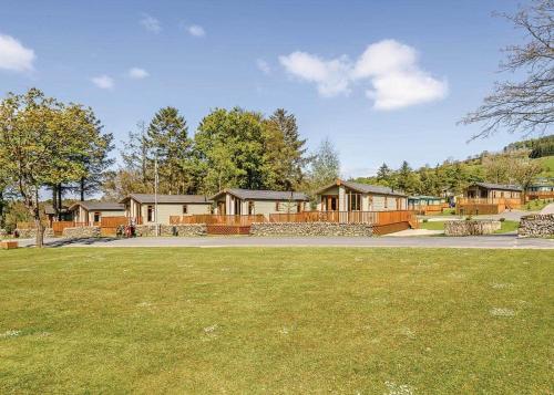 a row of houses in a park with a grass field at Hillcroft Park in Pooley Bridge