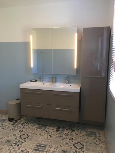 une salle de bain avec un lavabo et un miroir dans l'établissement Appart 175m2 idéalement situé Stationnement gratuit bas villa, à Ajaccio