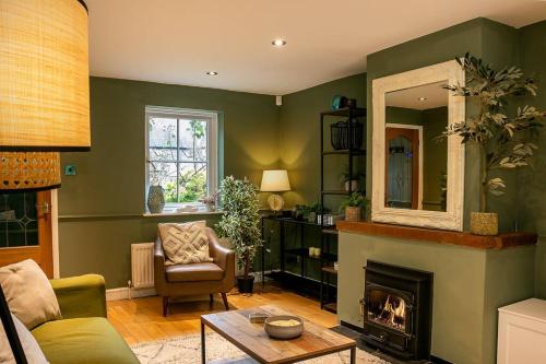 ein Wohnzimmer mit einem Kamin und einem Spiegel in der Unterkunft Stunning 3BD Oxfordshire Cottage in Enstone in Enstone