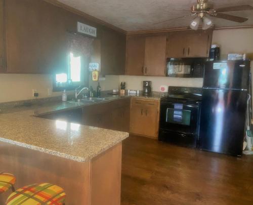 cocina con nevera negra y armarios de madera en Read Haven 3 Bedroom, 1.5 Bath, en Twain Harte