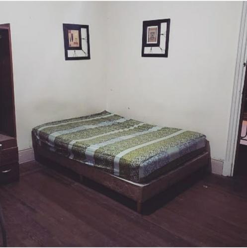 a bed in a room with two pictures on the wall at Centrico Hotel BA in Buenos Aires