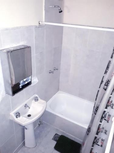 a white bathroom with a sink and a toilet at Centrico Hotel BA in Buenos Aires