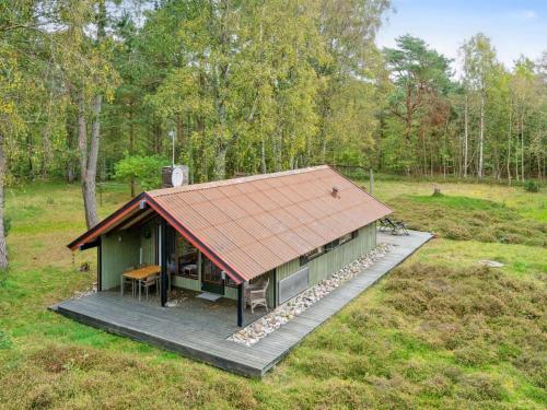 une petite maison verte avec un toit sur un champ dans l'établissement Holiday Home Esteri - 800m from the sea in NE Jutland by Interhome, à Læsø