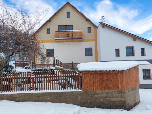 a house with a fence in the snow at Apartment Marika 2 by Interhome in Cerny Dul