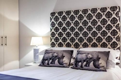 a bed with two bears pillows on it at Executive 1 Bedroom in Canal Quays in Cape Town