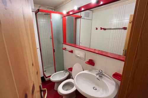 a bathroom with a sink and a toilet and a mirror at Casa a Cervinia sulle piste in Breuil-Cervinia
