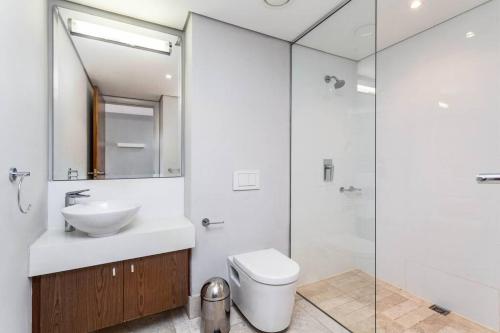 a bathroom with a sink and a toilet and a shower at Executive 1 Bedroom in Canal Quays in Cape Town