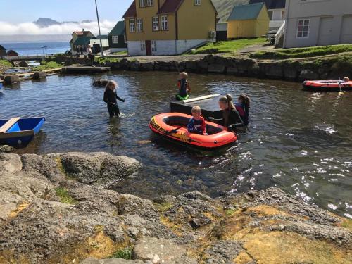 a group of children in a boat in the water at Luxury Cottage with Stunning Views - Okkara summarhús við Gjógv in Við Gjógv