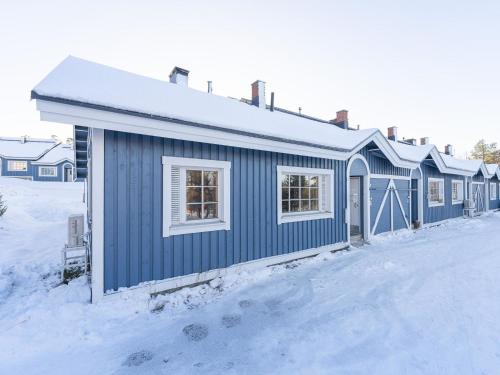 un edificio azul con nieve en el suelo en Holiday Home Teerenpesue a 5 by Interhome, en Saariselkä