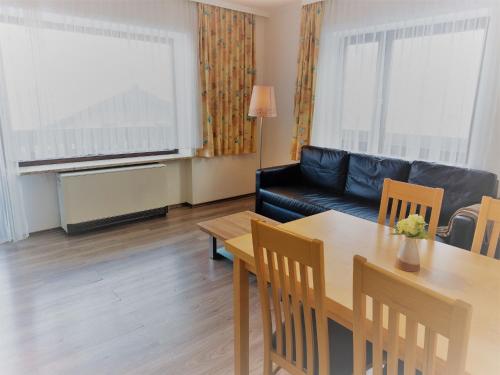 - un salon avec une table et un canapé noir dans l'établissement Apartment Landhaus St- Georg-3 by Interhome, à Bad Gastein