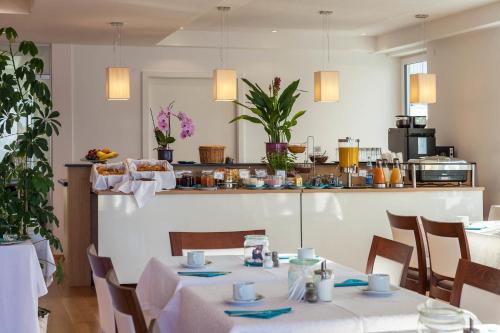 una sala da pranzo con due tavoli e una cucina di Seehotel BelRiva a Hagnau