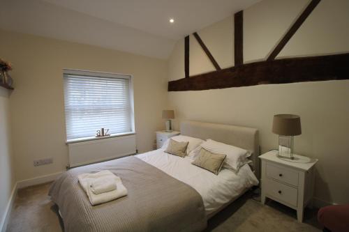 a bedroom with a bed with white sheets and a window at The Warren @ Short Stays in Basingstoke