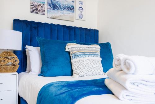 a bed with blue and white pillows on it at London Bridge 2 Bed Apartment - Sleeps 3 in London