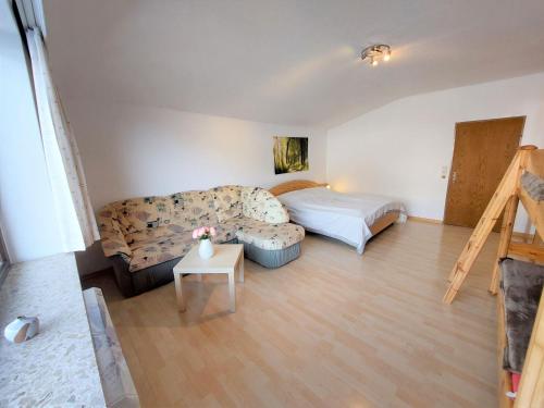 een woonkamer met een bank en een bed bij Apartment Landhaus St- Georg-8 by Interhome in Bad Gastein