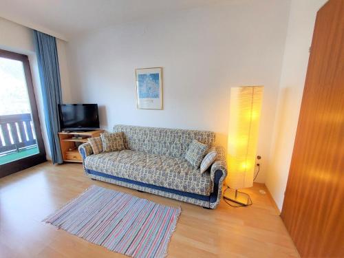 een woonkamer met een bank en een televisie bij Apartment Landhaus St- Georg-5 by Interhome in Bad Gastein