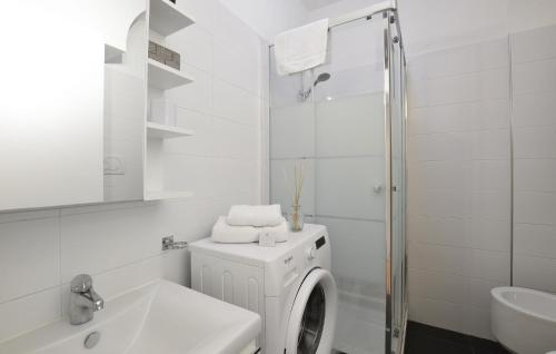 bagno bianco con lavatrice e lavandino di Stunning Apartment In Milano With Kitchen a Milano