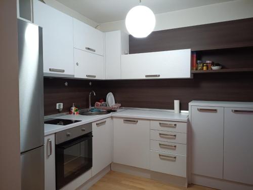 a white kitchen with white cabinets and a sink at Karpos- City Mall in Skopje