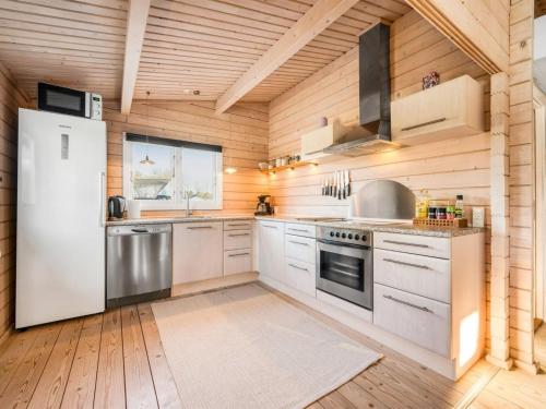 cocina con electrodomésticos blancos y paredes de madera en Holiday Home Joar - 11km from the sea in Western Jutland by Interhome, en Oksbøl