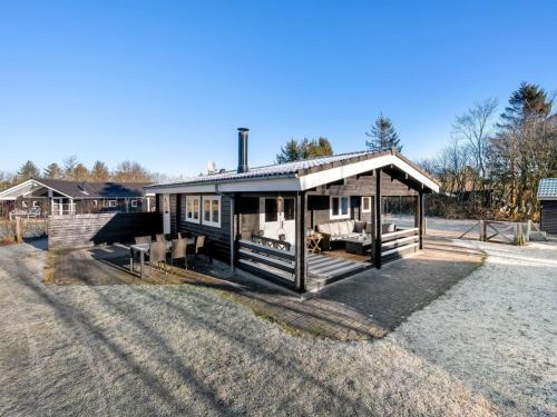 una pequeña casa con un porche en un campo en Holiday Home Joar - 11km from the sea in Western Jutland by Interhome, en Oksbøl