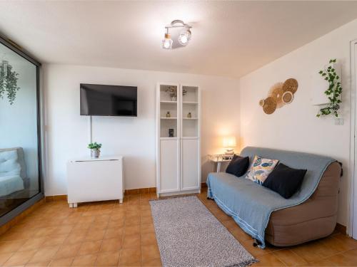 uma sala de estar com um sofá e uma televisão de ecrã plano em Apartment Les Maisons sur la Plage-12 by Interhome em Narbonne Plage