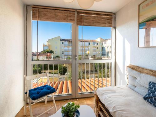 uma sala de estar com uma grande janela com vista para uma varanda em Apartment Les Maisons sur la Plage-12 by Interhome em Narbonne Plage