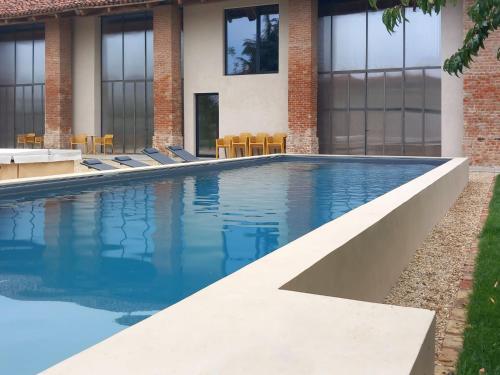 a swimming pool in front of a building at Villa We Rural by Interhome in Poirino