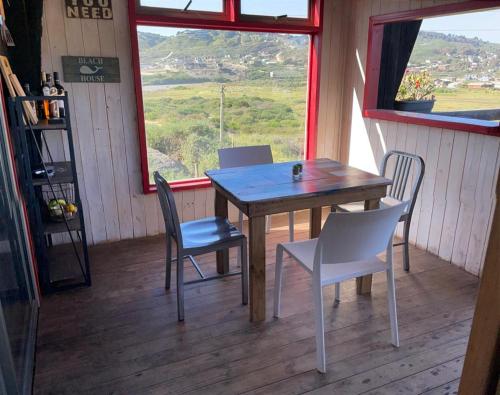 a table and chairs in a room with a window at Cabaña con tinaja a pasos de la playa in Boca Pupuya