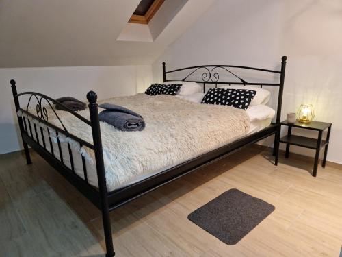 a black bed with pillows on it in a room at AIRPORT APARTMENS President and Black&White in Velika Gorica