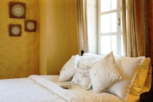 a bed with white pillows in a room with a window at Morro Alacati in Alacati