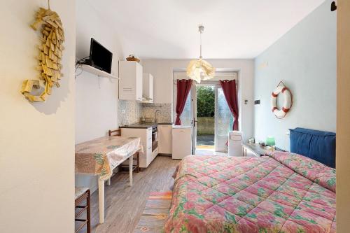 a bedroom with a bed and a kitchen and a table at Goccia di mare with free parking in Levanto