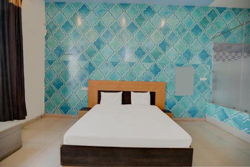 a bedroom with a bed and a blue wall at Super OYO The Royals Inn in Alīgarh
