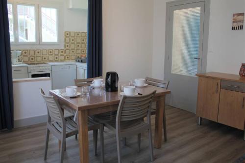 une cuisine avec une table en bois et des chaises ainsi qu'une salle à manger dans l'établissement Ronce-les-Bains - APPARTEMENT REZ-DE-CHAUSSEE gauche - 90m de la PLAGE, à Ronce-les-Bains