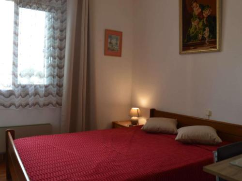 - une chambre avec un lit rouge et une fenêtre dans l'établissement Appartement familial proche plage avec terrasse, parking privé, au Grau-du-Roi - FR-1-250-136, au Grau-du-Roi