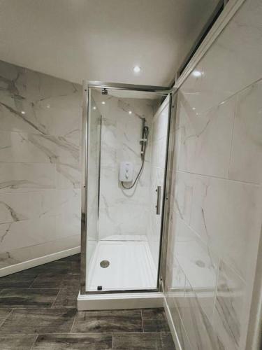 a shower with a glass door in a bathroom at Stunning 3-Bed House in Oldbury in Birmingham