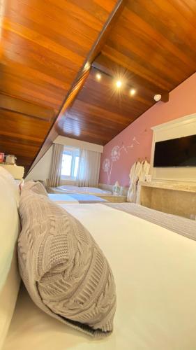a bedroom with a large bed with a wooden ceiling at Blumen Hotel Boutique in Canela