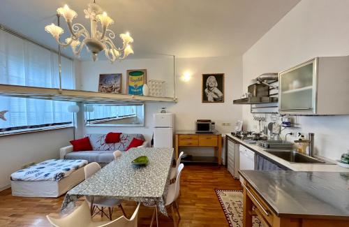 Art District Loft Venice في البندقية: مطبخ وغرفة معيشة مع طاولة وأريكة