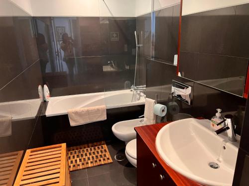 a bathroom with a white toilet and a sink at Apartamento Vitória in Praia da Vitória