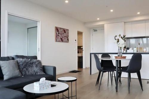 ein Wohnzimmer mit einem Sofa und einem Tisch mit Stühlen in der Unterkunft 1 BRM 1 BATH, South Melbourne, Spacious, Balcony in Melbourne