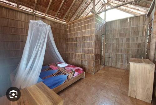 a room with a bed with a mosquito net at Binmeos Homestay in Waisai