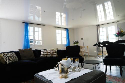 a living room with a couch and a table at EXIGEHOME-Maison avec piscine et tennis à 30 min de Paris in Saint-Gratien