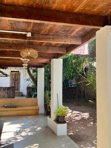 a patio with a wooden ceiling and a chandelier at The Sunset Chalet in Anjuna