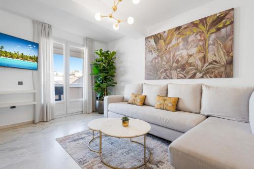 uma sala de estar branca com um sofá e uma mesa em Tennessee Penthouse em Málaga
