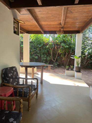 a patio with a table and chairs under a wooden ceiling at The Sunset Chalet! in Anjuna