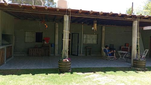 un uomo seduto su una sedia sotto un pergolato di El Indio - Casa de campo a Villa del Salvador