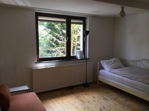 1 dormitorio con ventana y 1 cama. en 30' bus/train to Vienna, lange flat, min.4 nights, en Klosterneuburg