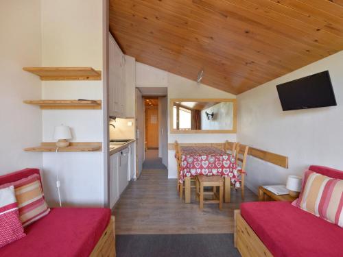 Cette chambre comprend une salle à manger et une cuisine avec une table. dans l'établissement Appartement fonctionnel de 2 pièces avec balcon et casier à ski - FR-1-181-2155, à La Plagne Tarentaise