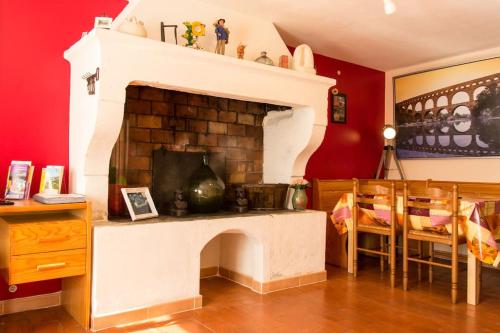 ein Wohnzimmer mit einem Kamin und einer roten Wand in der Unterkunft Maison tout confort, climatisée, dans le Centre Historique avec parking privé. in Saint-Rémy-de-Provence